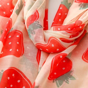 Detailed close-up of soft linen-touch scarf featuring vibrant red strawberry print