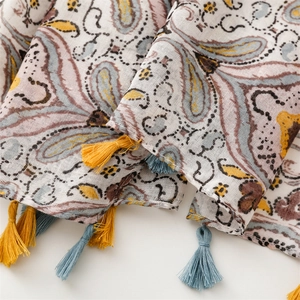 Macro shot of paisley pattern and colorful tassel fringes on lightweight ethnic scarf