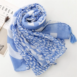 Close-up of blue leopard print scarf with soft tassels and geometric patterns