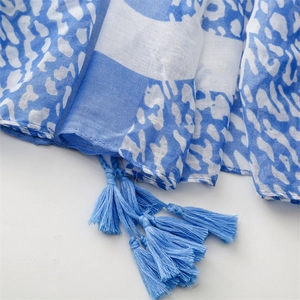 Detailed shot of leopard print scarf with fringe edges and lightweight cotton-linen texture