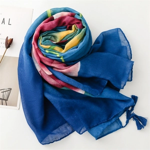 Detail of dark blue scarf with vibrant floral patterns and elegant tassel trim