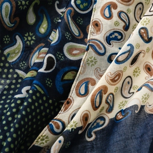 Detailed macro view of retro paisley pattern shawl with layered navy and beige fabric texture