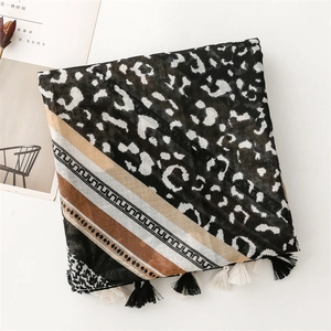 Detail of leopard print and geometric stripe scarf with elegant black and white tassels