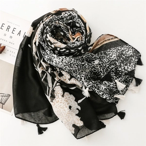 Flat lay of leopard and floral print scarf with fringes next to a lifestyle magazine