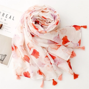 Detailed view of lightweight scarf with orange ginkgo leaves and soft fringe tassels