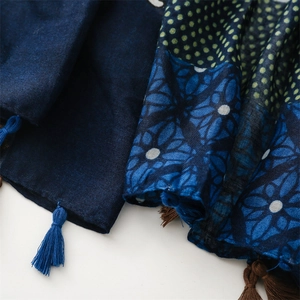 Detailed close-up of ethnic style shawl with floral patterns and handmade fringe tassels