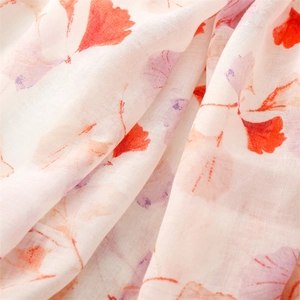 Detail view of light floral printed voile scarf showing soft orange and purple patterns