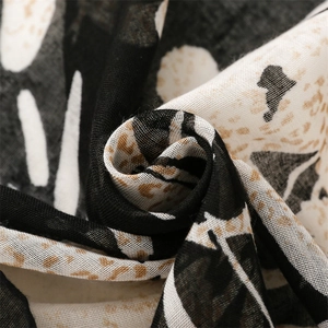 Detail shot of leopard and floral print scarf fabric showing soft weave texture
