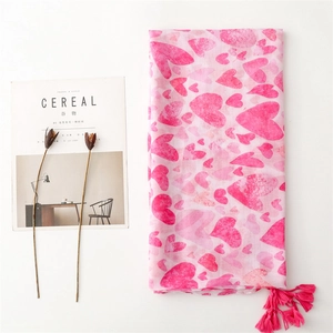 Detailed view of pink cotton linen scarf with heart patterns and decorative tassels