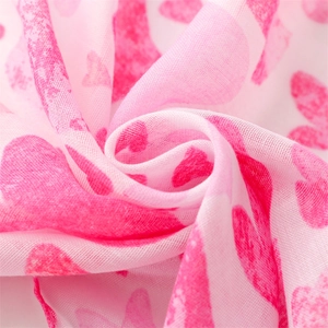 Macro shot of breathable cotton-linen scarf with pink heart print and soft texture