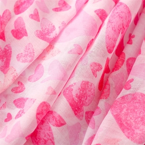 Detailed macro view of soft pink cotton-linen scarf fabric with romantic heart print