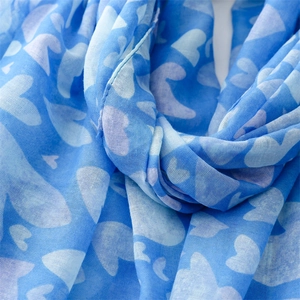 Detailed close-up of blue heart-print scarf fabric showing breathable linen-like texture