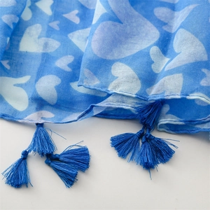 Detailed view of blue heart print scarf featuring elegant matching tassel edge decorations