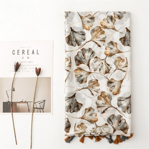 Ginkgo leaf print shawl scarf with colorful tassels, laid flat in minimalist setting
