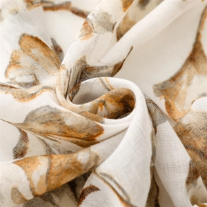 Close-up of semi-transparent scarf fabric with brown ginkgo leaf pattern and fine texture