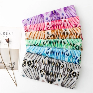 Flat lay of cotton linen scarves with geometric gold foil prints in six vibrant colors