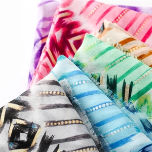 Close-up of geometric gold foil scarves with frayed edges in various vibrant colors