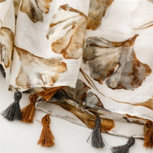 Detailed close-up of soft ginkgo leaf print scarf with stylish two-tone tassels