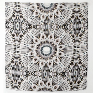 Detail of square scarf with gold geometric kaleidoscope print and fringed edges