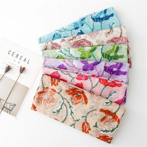 Detail of floral linen scarves in multiple colors with golden peony prints and frayed edges