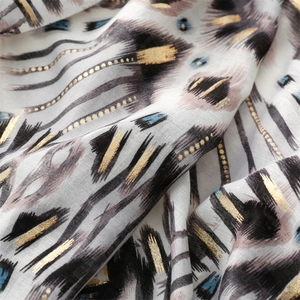 Macro detail of abstract geometric patterns with gold foil on soft cotton-linen scarf