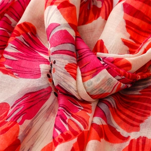 Macro detail of breathable cotton-linen scarf with red floral prints and woven texture