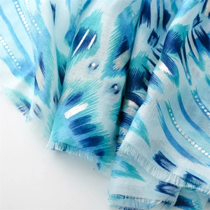 Macro detail of blue cotton-linen scarf with silver metallic geometric prints and fringe