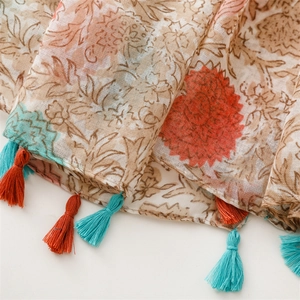 Close-up of vintage floral cotton scarf showing fine fabric texture and colorful tassels