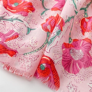 Detail of pink cotton linen scarf featuring gold foil poppy print and frayed edges