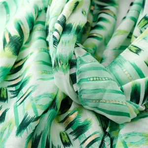 Detailed texture of cotton linen feel scarf with golden foil tropical leaf patterns