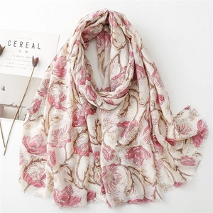 Linen feel scarf with gold-foil peony print and tassels, draped by a Cereal magazine