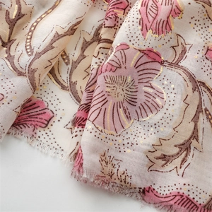 Detailed close-up of gold leaf flower printing and fringe edges on cotton linen shawl