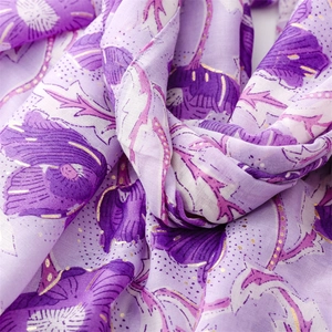 Detail of purple scarf featuring golden foil flower patterns and soft cotton linen texture