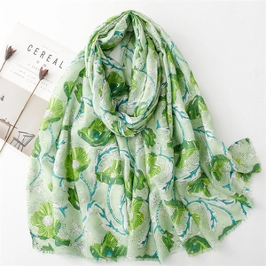 Detail of green floral scarf with gold stamping peony patterns and frayed edges