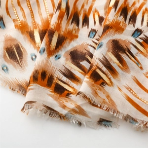 Detail of cotton linen scarf with gold foil geometric patterns and frayed tassel edges