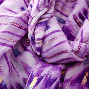 Detailed macro view of purple cotton-linen scarf with gold foil geometric dots and patterns