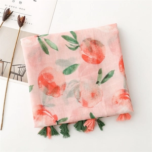 Detail of light pink peach print scarf with soft cotton-linen texture and colorful fringe