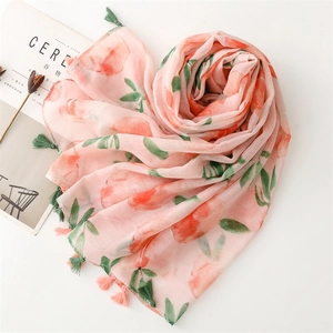 Detail view of light pink peach print scarf with green fringes and linen texture