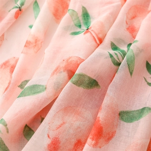 Macro shot of breathable cotton-linen scarf featuring vivid peach and leaf print patterns