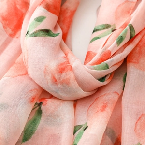 Detail of soft cotton linen scarf featuring a watercolor peach and leaf print pattern