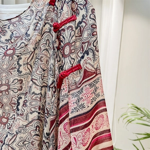 Close-up of red Chinese frog buttons on a floral print silk shawl for women