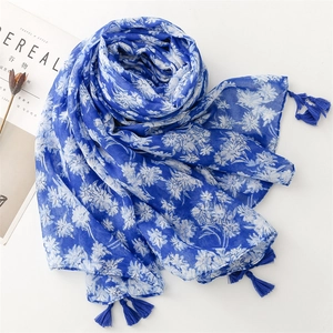 Détail d'une écharpe fleurie bleue légère avec franges élégantes et toucher lin