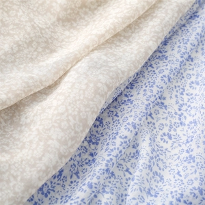 Macro shot of lightweight cotton-linen fabric with vintage floral prints and natural texture