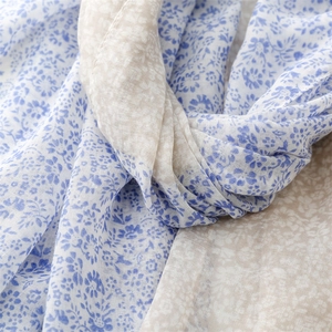 Detail of floral printed scarf showing soft cotton-linen texture and delicate rolled edges