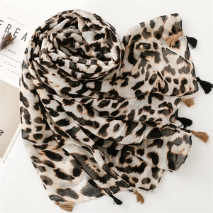 Detail of leopard print scarf featuring beige cotton-linen fabric and tassel edges
