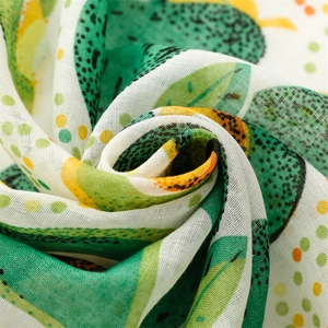 Macro view of a breathable linen scarf featuring avocado prints and colorful polka dots