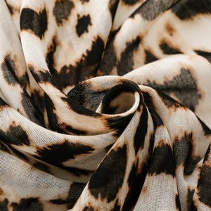 Macro detail of leopard print scarf fabric showing light linen texture and weave pattern
