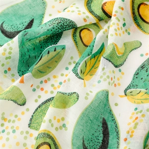Close-up of lightweight linen texture fabric featuring cute avocado and leaf prints