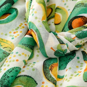 Close-up of lightweight linen-feel scarf featuring fresh green avocado prints and dots