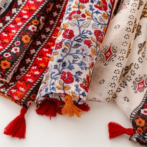 Detail shot of ethnic print scarf featuring boho floral patterns and fringe tassels